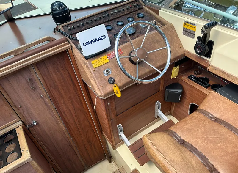 Slide: The Image of 1981 Sea Ray V240 boat cockpit with steering wheel and navigation equipment. - 10