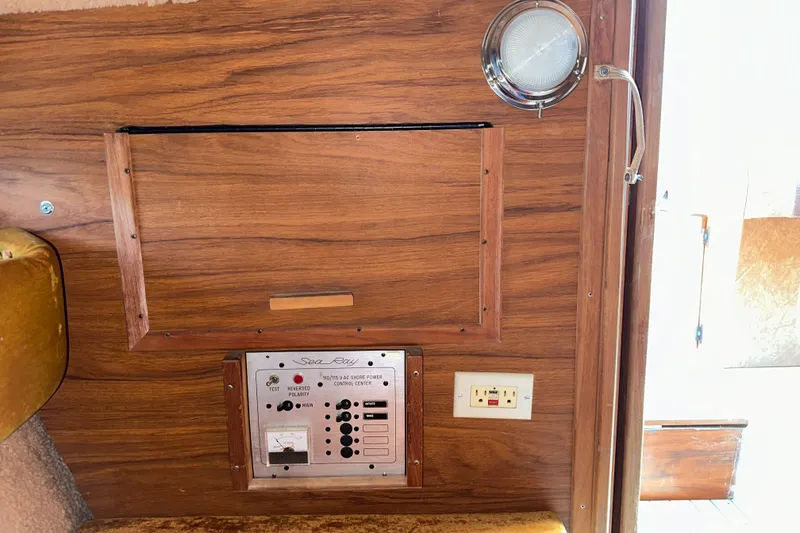 Slide: The Image of 1981 Sea Ray V240 interior panel with wood finish and control switches. - 16