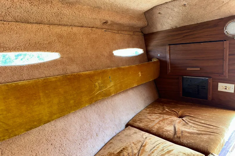 Slide: The Image of Interior of 1981 Sea Ray V240 boat with vintage upholstery and wood paneling. - 17