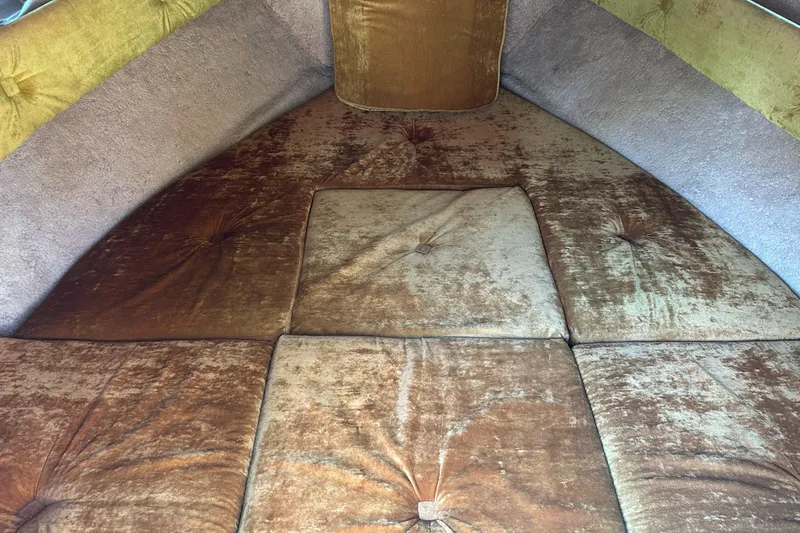 Slide: The Image of Vintage 1981 Sea Ray V240 boat interior with brown cushioned seating. - 18