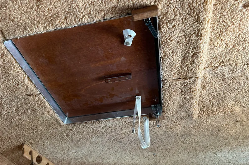 Slide: The Image of 1981 Sea Ray V240 boat hatch with wooden finish and latch mechanism. - 20