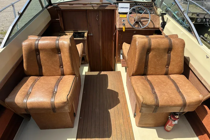 Slide: The Image of 1981 Sea Ray V240 boat interior with brown leather seats and wooden dashboard. - 5