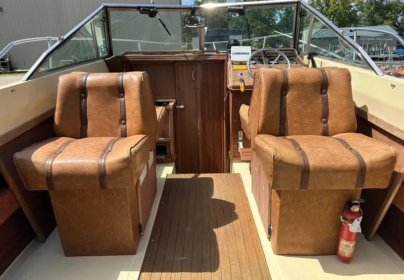 Slide: The Image of 1981 Sea Ray V240 boat interior with brown leather seats and wooden accents. - 6