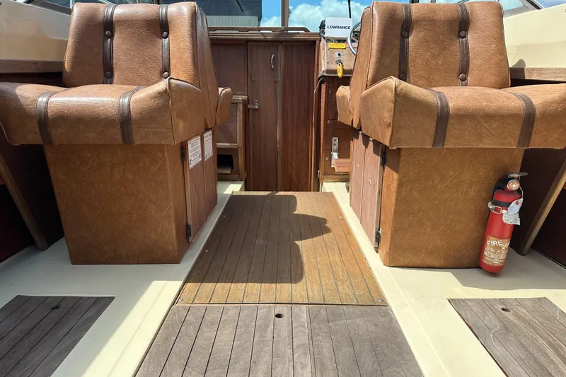 Slide: The Image of Interior of 1981 Sea Ray V240 boat with brown leather seats and wooden flooring. - 7