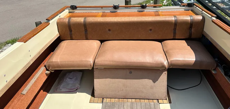 Slide: The Image of 1981 Sea Ray V240 boat interior with brown leather seating and wooden accents. - 8