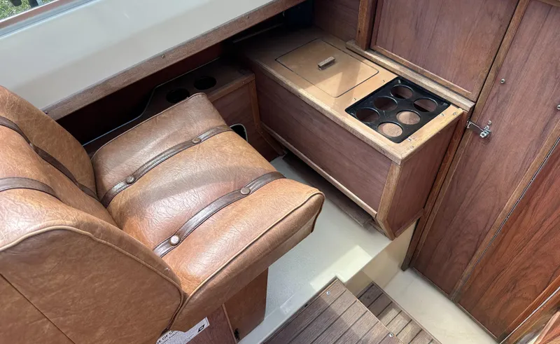 Slide: The Image of 1981 Sea Ray V240 interior with brown leather seats and wooden cabinetry. - 9
