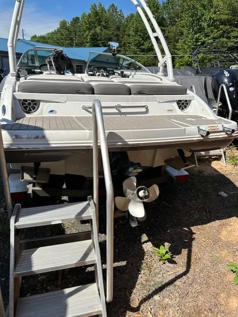 Slide: The Image of 2021 Crownline 220SS boat with swim platform and ladder, parked outdoors. - 15