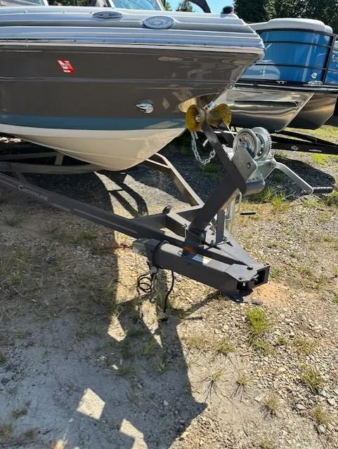 Slide: The Image of 2021 Crownline 220SS boat on trailer, parked on grassy area. - 16