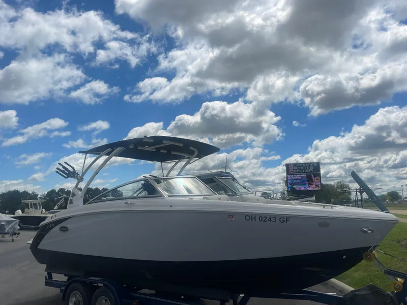 Slide: The Image of 2021 Cobalt R5 Surf boat on trailer under a partly cloudy sky. - 2