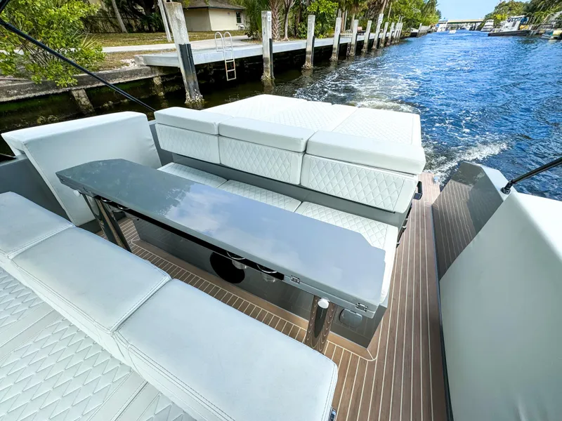 Slide: The Image of 2024 De Antonio Yachts D28 Cruiser, elegant seating area on deck, cruising along a scenic waterway. - 14