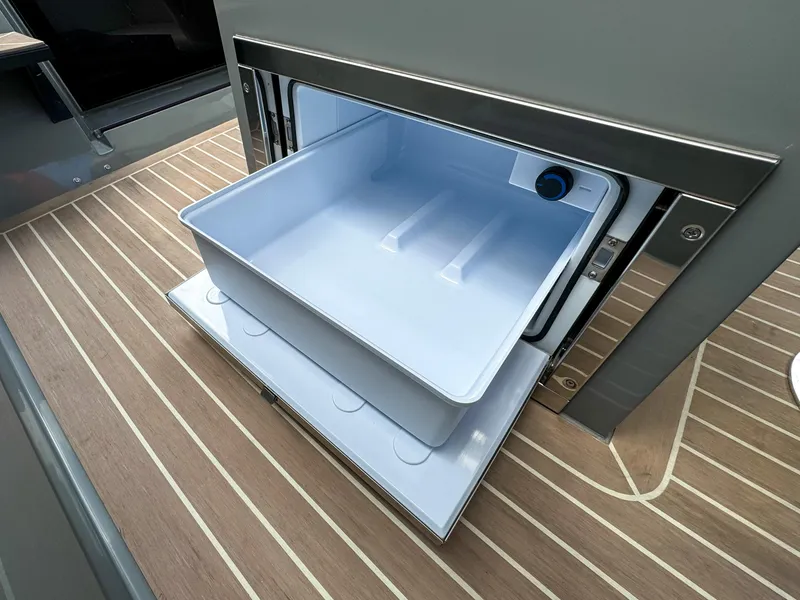 Slide: The Image of 2024 De Antonio Yachts D28 Cruiser interior with open storage compartment on wooden deck. - 17