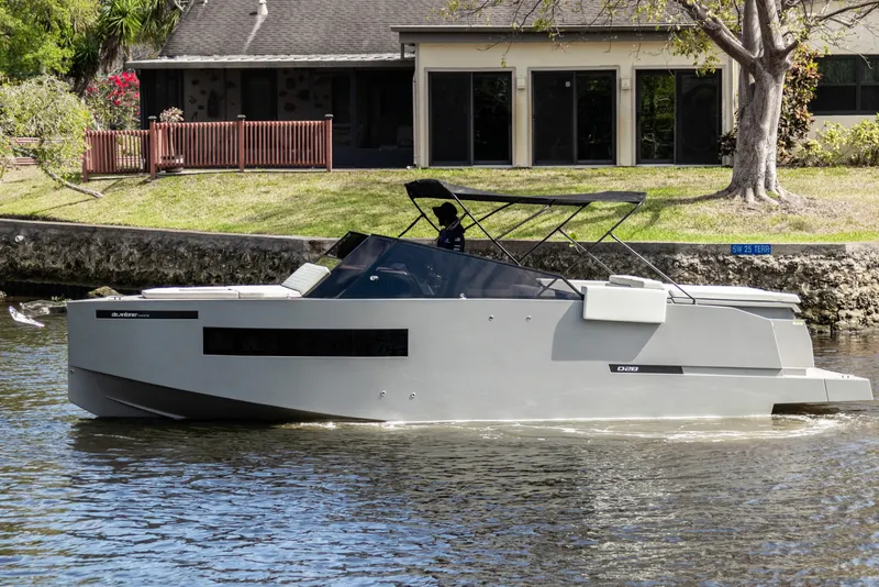 Slide: The Image of 2024 De Antonio Yachts D28 Cruiser on a serene waterway, modern design, sleek profile. - 19