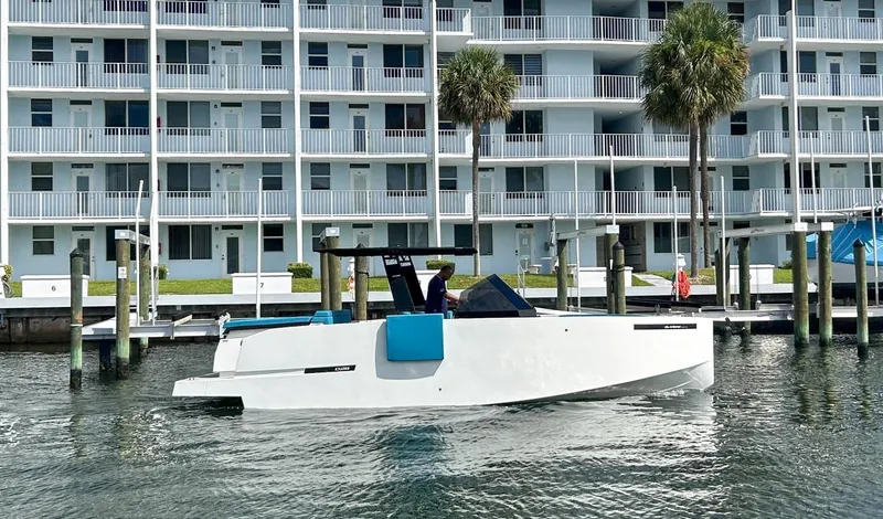 Slide: The Image of 2023 De Antonio Yachts D28 Open cruising near waterfront apartments. - 0