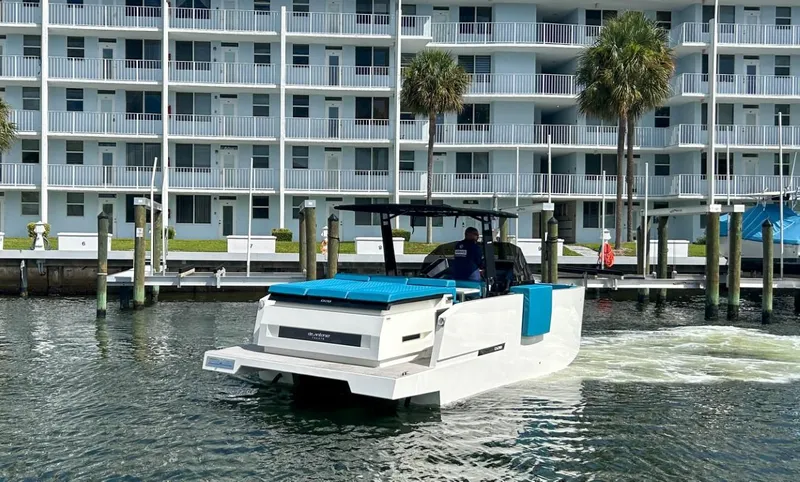 Slide: The Image of 2023 De Antonio Yachts D28 Open cruising near waterfront apartments. - 1