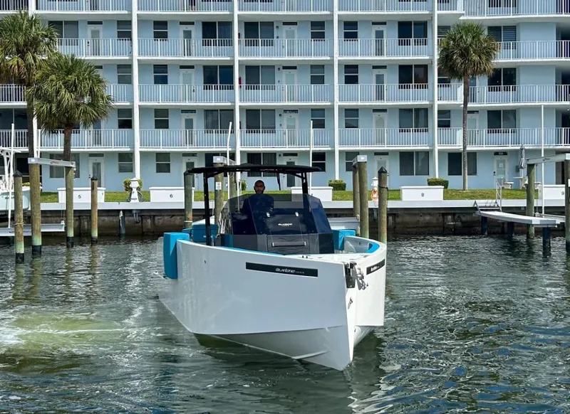 Slide: The Image of 2023 De Antonio Yachts D28 Open cruising near waterfront apartments. - 2