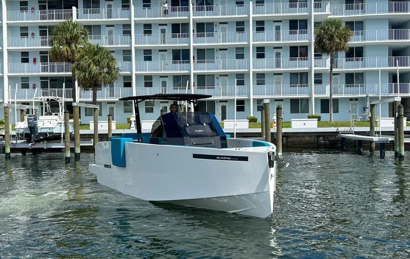 Slide: The Image of 2023 De Antonio Yachts D28 Open cruising near waterfront apartments. - 5