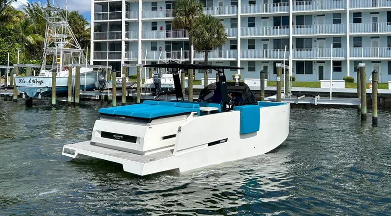 Slide: The Image of 2023 De Antonio Yachts D28 Open cruising near a marina with modern buildings. - 6