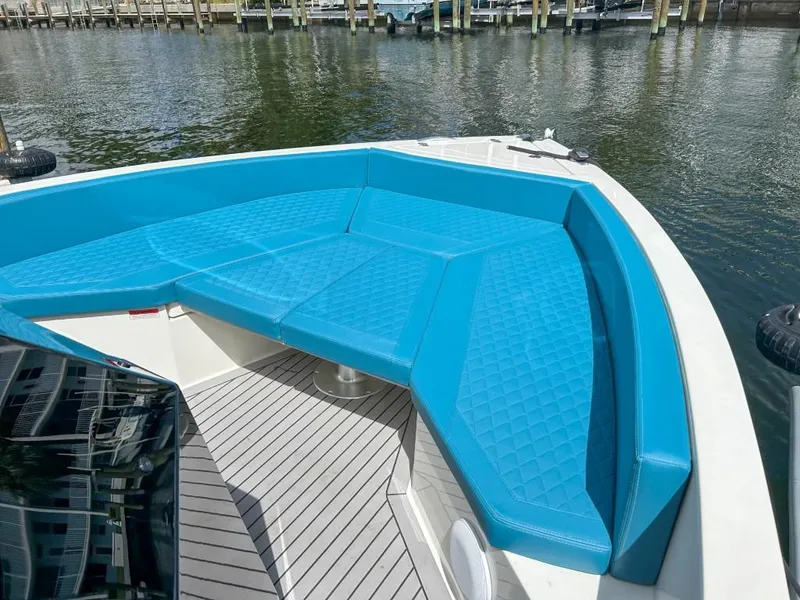 Slide: The Image of 2023 De Antonio Yachts D28 Open with blue seating, docked by the water. - 8