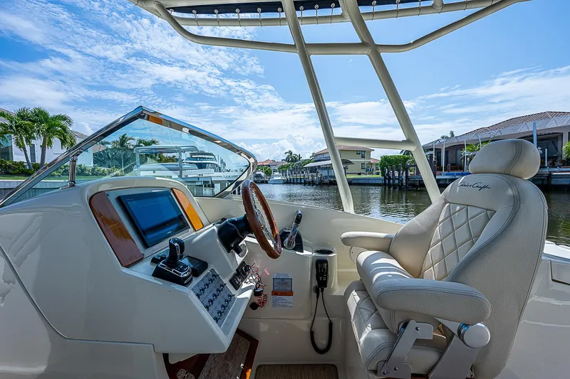 Slide: The Image of Interior of 2018 Chris-Craft Calypso 26 boat with steering wheel and captain's chair. - 12