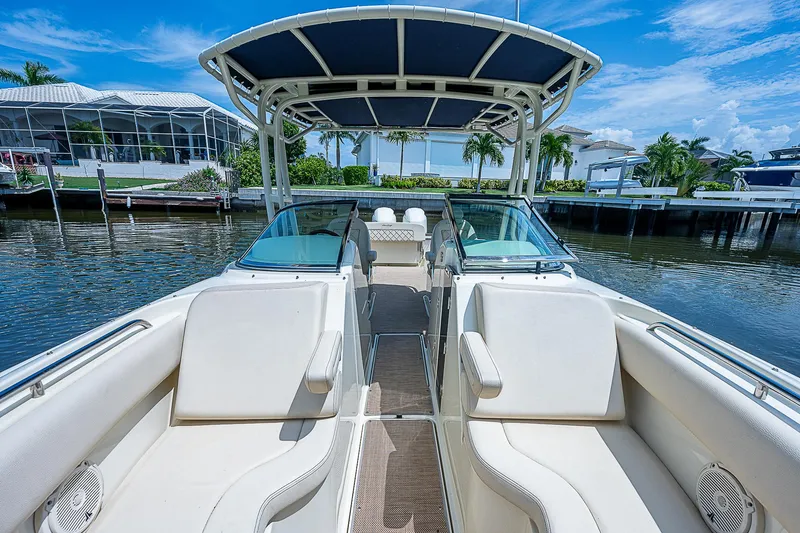 Slide: The Image of 2018 Chris-Craft Calypso 26 boat with spacious seating and canopy on a sunny day. - 18