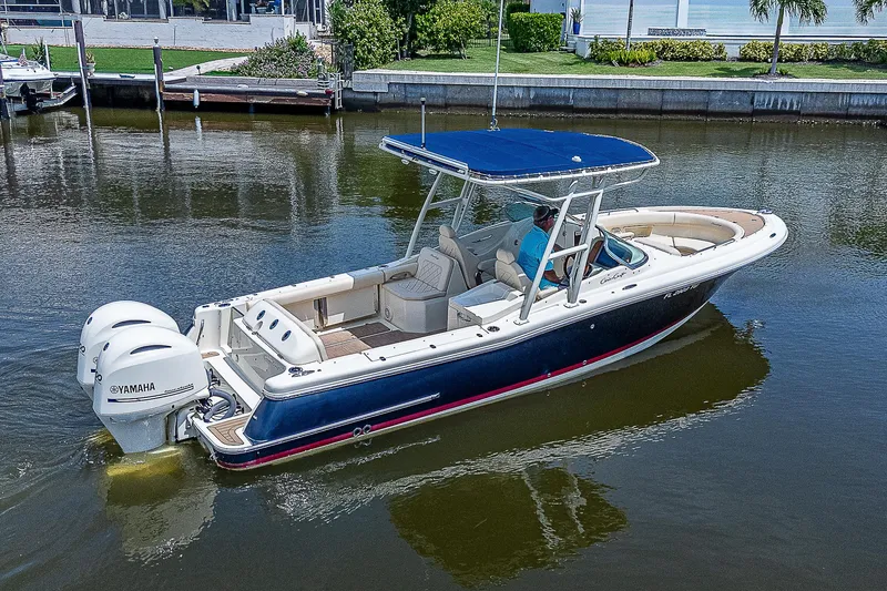Slide: The Image of 2018 Chris-Craft Calypso 26 boat with dual engines on a calm waterway. - 2