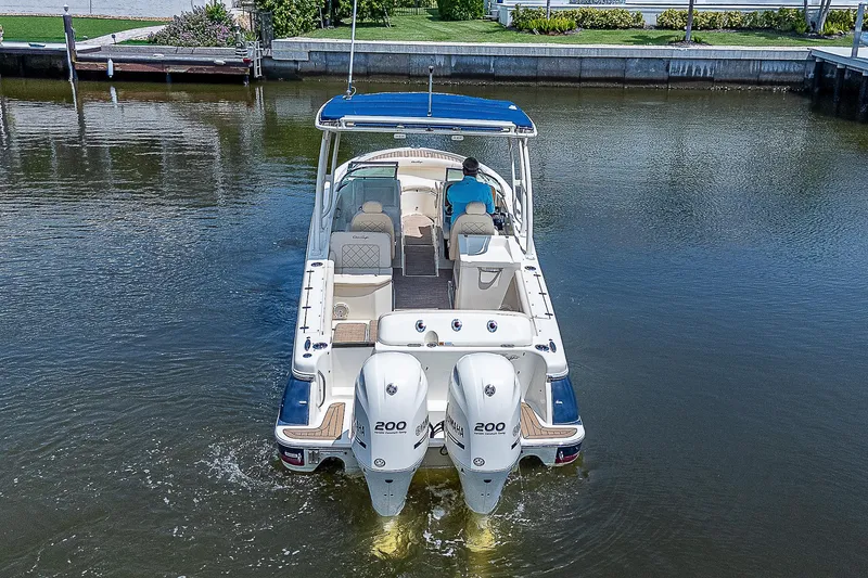 Slide: The Image of 2018 Chris-Craft Calypso 26 boat with dual engines on a calm waterway. - 3