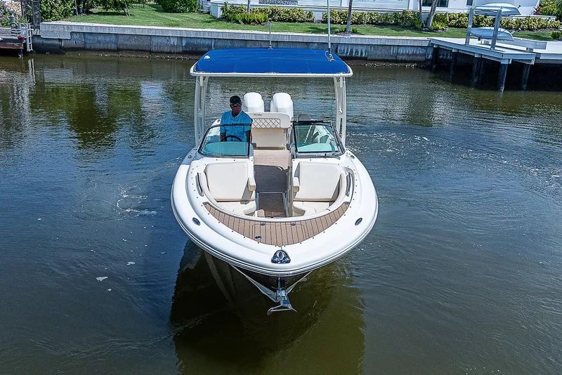 Slide: The Image of 2018 Chris-Craft Calypso 26 boat on calm water, featuring a blue canopy. - 6