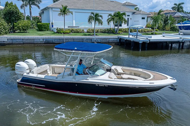 Slide: The Image of 2018 Chris-Craft Calypso 26 boat cruising in a scenic waterfront setting. - 7