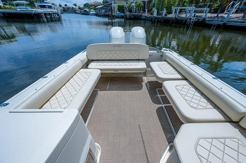 Slide: The Image of 2018 Chris-Craft Calypso 26 boat interior with spacious seating on a calm waterway. - 8