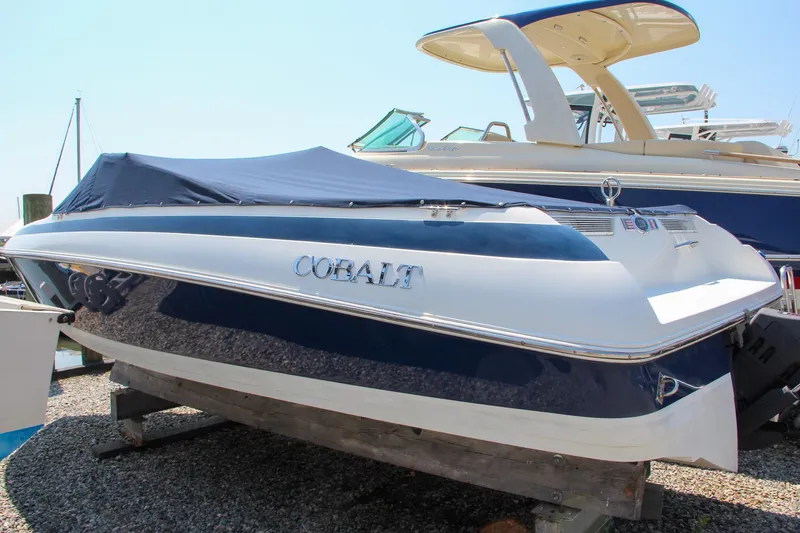 Slide: The Image of 1996 Cobalt 220 boat with blue cover, displayed on a wooden stand. - 10