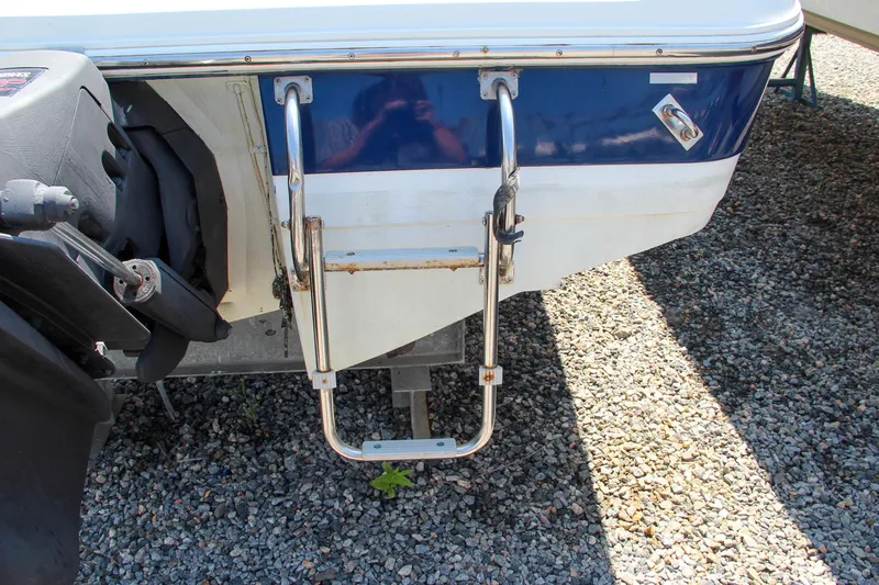 Slide: The Image of 1996 Cobalt 220 boat stern with ladder on gravel surface. - 14
