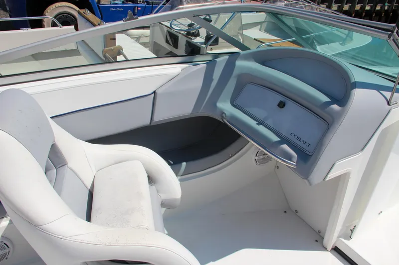 Slide: The Image of Interior of a 1996 Cobalt 220 boat with white seating and dashboard. - 17