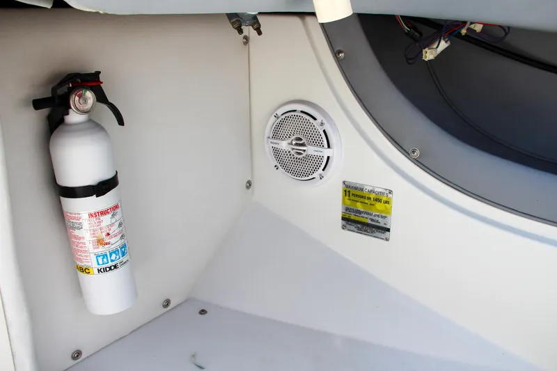Slide: The Image of Fire extinguisher and speaker inside 1996 Cobalt 220 boat compartment. - 22