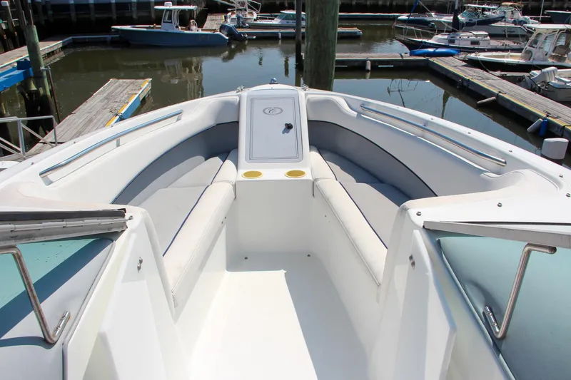 Slide: The Image of 1996 Cobalt 220 boat interior with cushioned seating at a marina. - 5