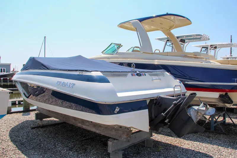 Slide: The Image of 1996 Cobalt 220 boat on display, covered and docked, with another boat in the background. - 9