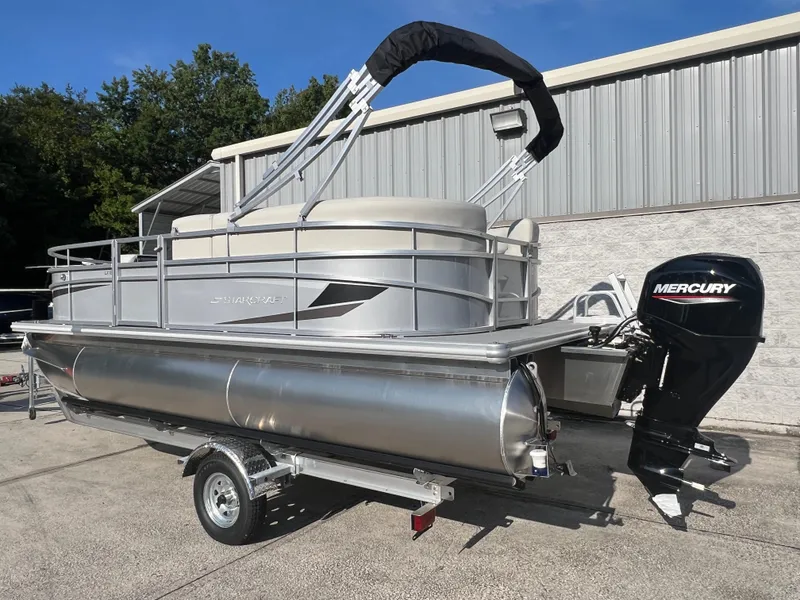 Slide: The Image of 2025 Starcraft LX 18 F pontoon boat with Mercury outboard motor on trailer. - 1