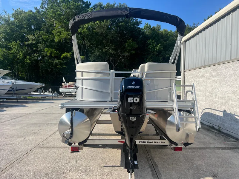 Slide: The Image of 2025 Starcraft LX 18 F pontoon boat with Mercury 60 engine, parked outdoors. - 11