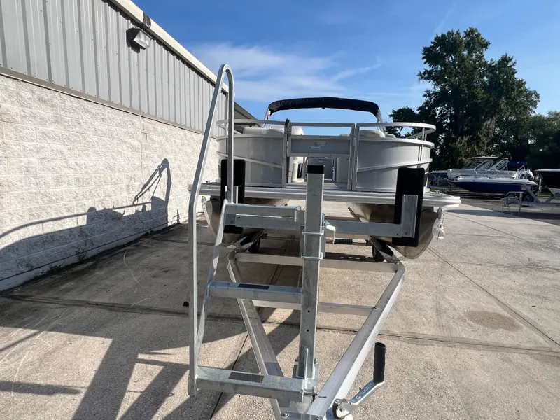 Slide: The Image of 2025 Starcraft LX 18 F boat on trailer, parked outdoors under clear sky. - 12