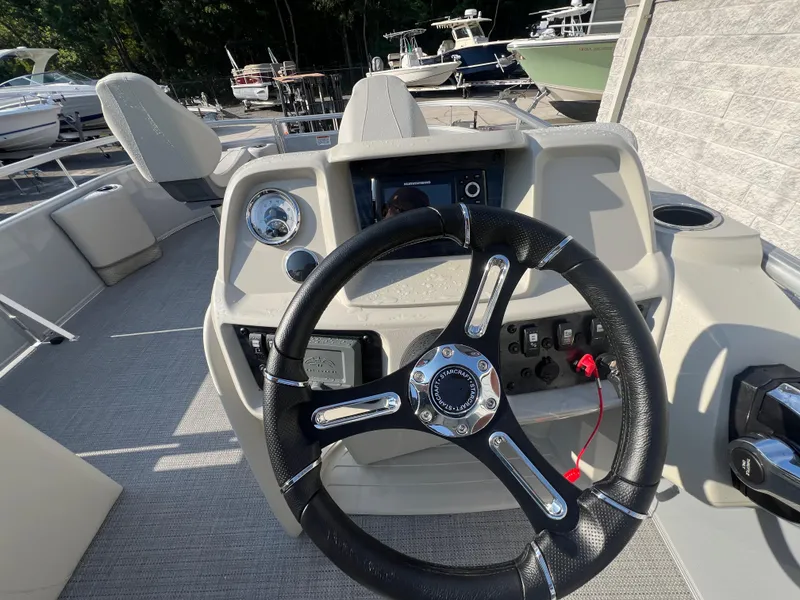 Slide: The Image of 2025 Starcraft LX 18 F boat dashboard with steering wheel and control panel. - 15