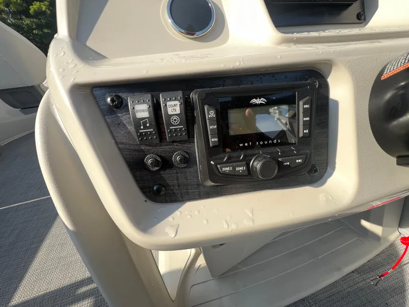 Slide: The Image of Control panel of 2025 Starcraft LX 18 F boat with audio system and switches. - 16