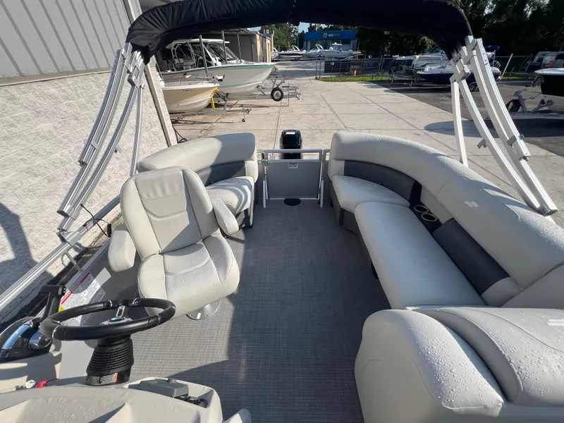 Slide: The Image of 2025 Starcraft LX 18 F pontoon boat interior with seating and steering wheel. - 5