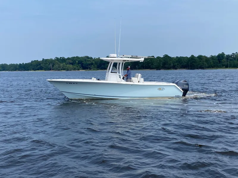 Slide: The Image of 2014 Sea Hunt Game Fish 27 boat cruising on a calm lake. - 0