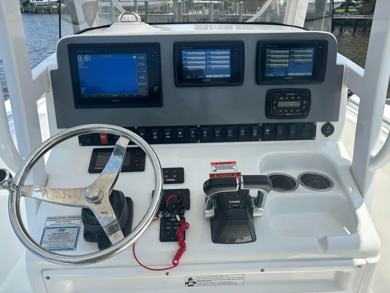 Slide: The Image of 2014 Sea Hunt Game Fish 27 dashboard with steering wheel and electronic controls. - 1