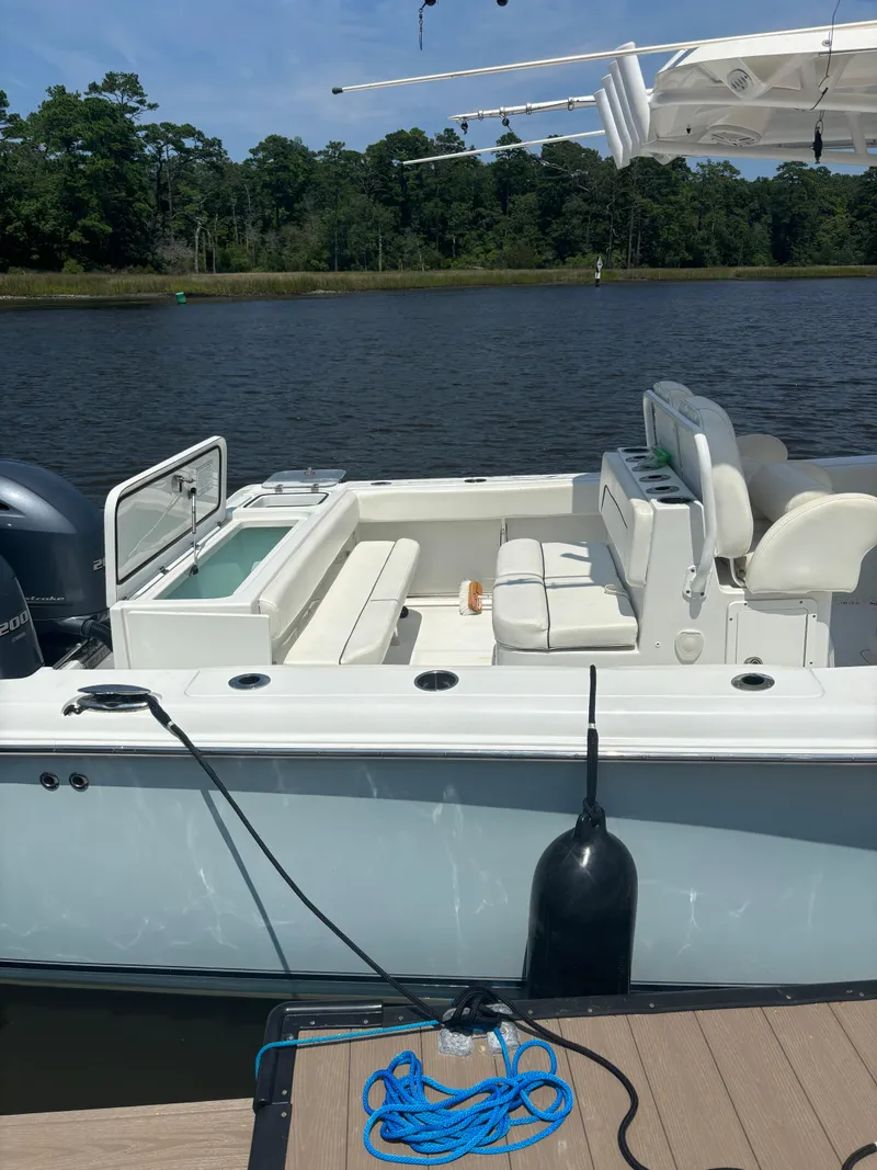 Slide: The Image of 2014 Sea Hunt Game Fish 27 boat docked by a serene lake. - 3
