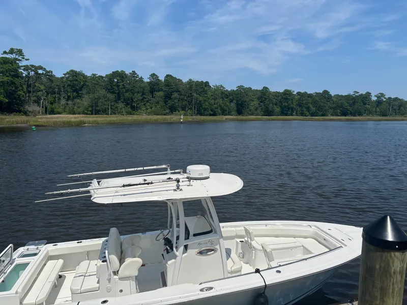 Slide: The Image of 2014 Sea Hunt Game Fish 27 boat docked on a serene lake. - 4