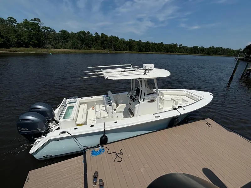 Slide: The Image of 2014 Sea Hunt Game Fish 27 boat docked on a calm river. - 5