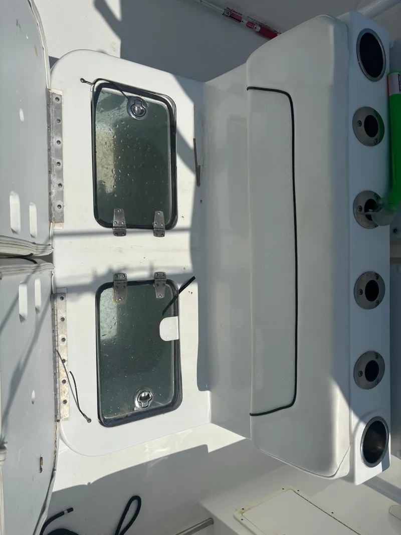 Slide: The Image of 2014 Sea Hunt Game Fish 27 boat interior with storage compartments and rod holders. - 6