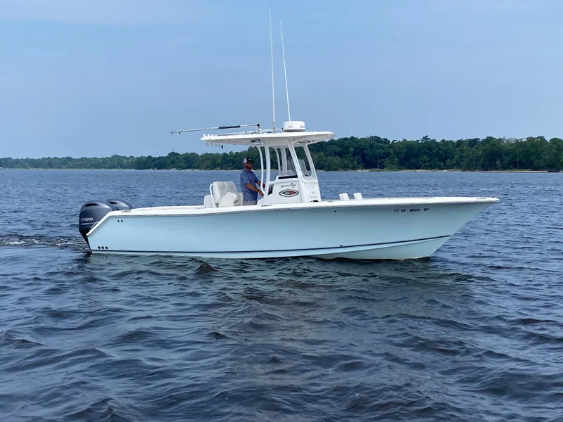 Slide: The Image of 2014 Sea Hunt Game Fish 27 boat on calm water, with a person onboard. - 7