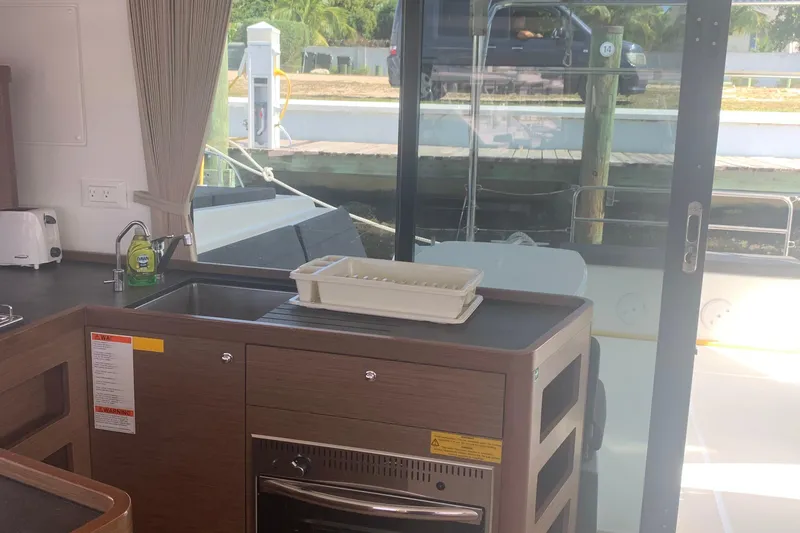 Slide: The Image of Interior of 2019 Lagoon 42 yacht kitchen with modern appliances and dockside view. - 11