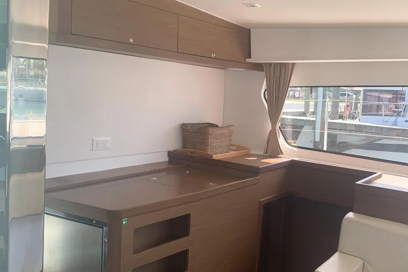 Slide: The Image of Interior of 2019 Lagoon 42 yacht with modern wood cabinetry and large window. - 13